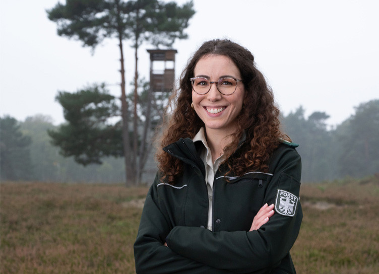 Frau im Wald in Försterinnenuniform